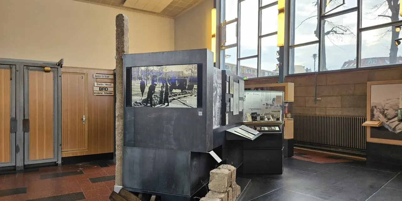 Ausstellung im "Palace of Tears" Berlin: Ein Stein, ein Bildschirm mit historischem Bild, und Ausstellungsstücke erinnern an die Teilung.