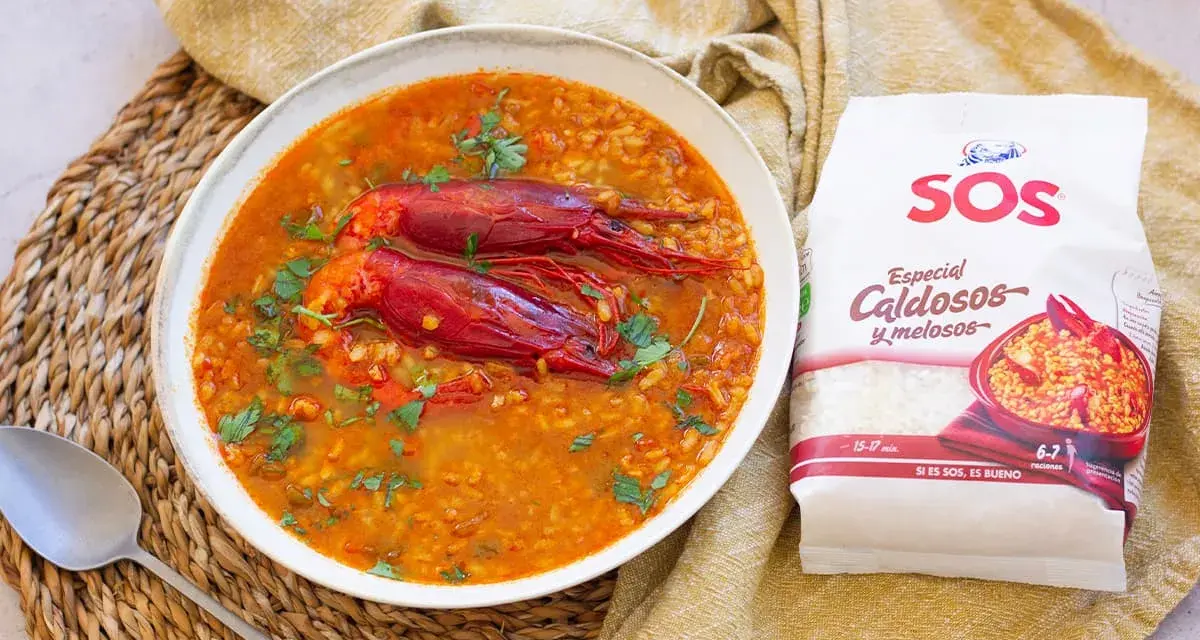 Un delicioso arroz caldoso con gambas rojas, adornado con perejil fresco. La bolsa de arroz SOS "Especial Caldosos y melosos" promete una preparación perfecta.
