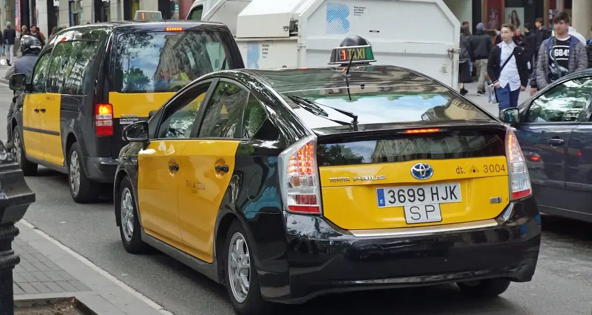 Gelbe Taxis in Barcelona, ein Toyota Prius und ein größeres Taxi XL, warten auf Fahrgäste.