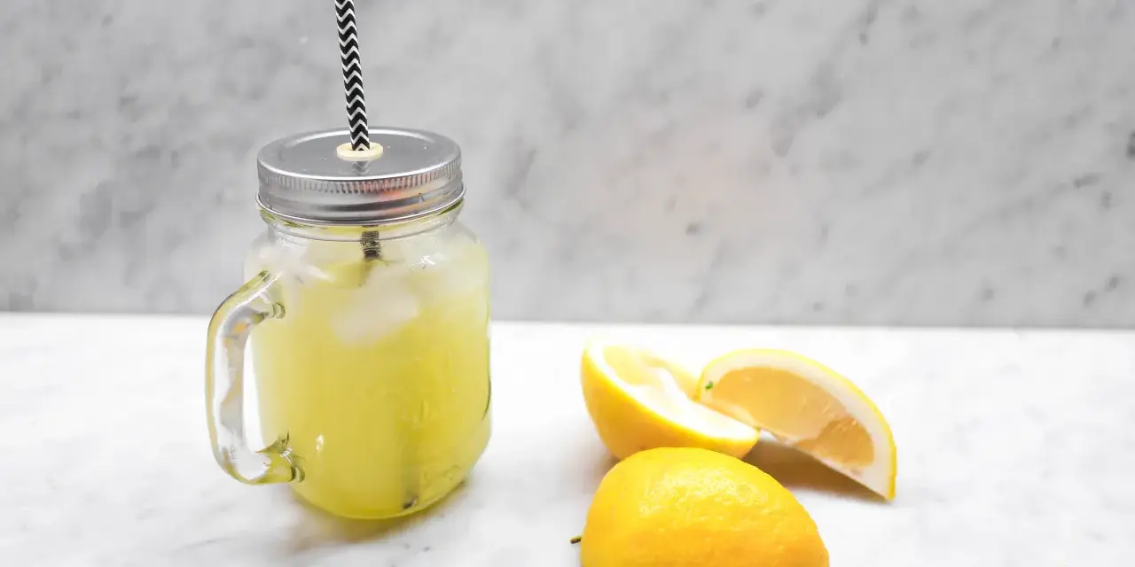 En burk med hemgjord lemonad, is och citronskivor. Perfekt för ett enkelt lemonad recept.