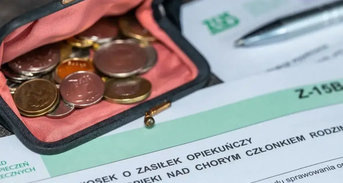 Portmonetka z monetami leży obok formularza ZUS Z-15B, który dotyczy wniosku o zasiłek opiekuńczy.