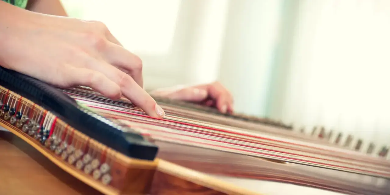 Hände spielen auf einem Hackbrett, das vielleicht das einfachste Instrument ist, um Melodien zu erzeugen.