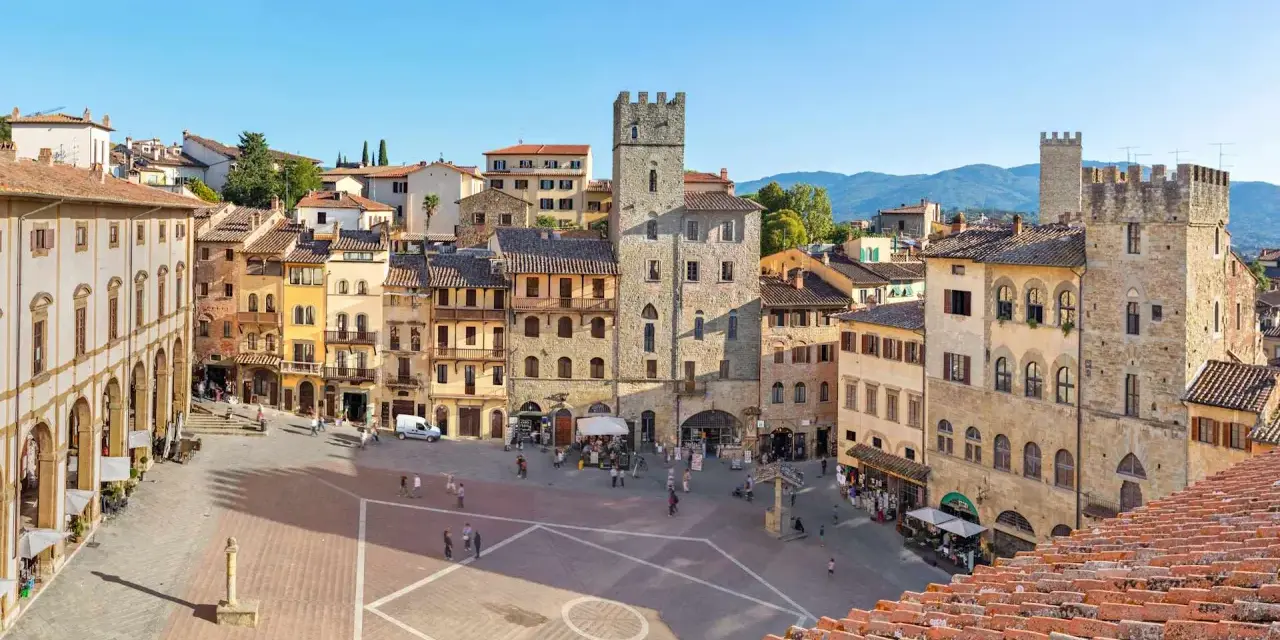 Piazza del Popolo ad Arezzo, con la torre medievale e i palazzi storici che incorniciano la piazza, un luogo incantevole nei dintorni.