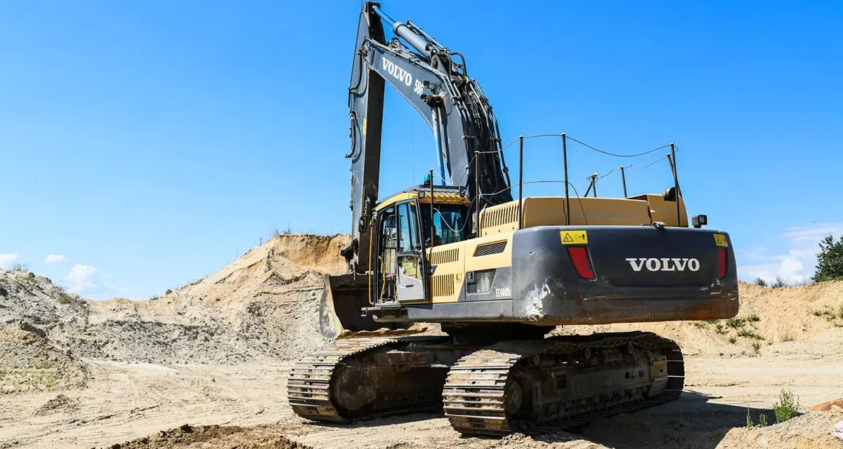 Koparka Volvo na placu budowy. Zastanawiasz się, ile kosztuje kurs na koparkę? Maszyna czeka na operatora.