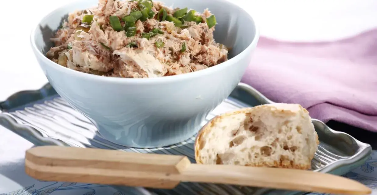 Pyszna pasta z tuńczyka i jajka, posypana szczypiorkiem, podana z kawałkiem chleba. Idealna na szybką przekąskę.