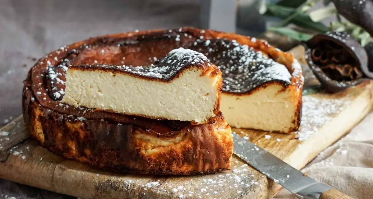 Tarta de queso La Viña, receta auténtica con su interior cremoso y exterior caramelizado, espolvoreada con azúcar glas.