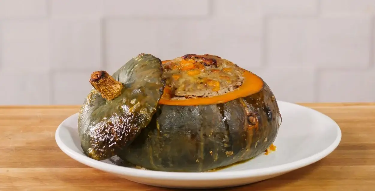 Deliziosa zucca ripiena, con un appetitoso ripieno dorato che fuoriesce dal suo guscio cotto.