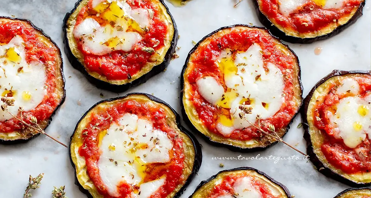 Pizzette di melanzane, gustose e colorate, con pomodoro, mozzarella filante e un filo d'olio.