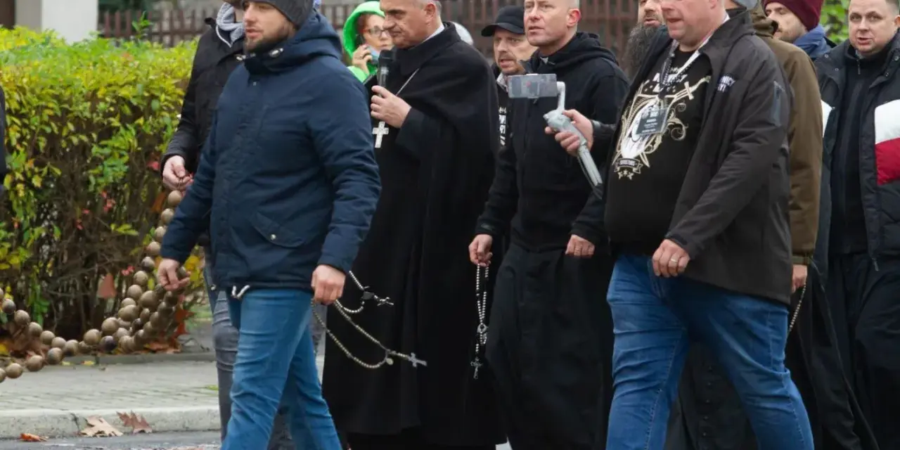 Grupa mężczyzn, w tym biskup, idzie ulicą. Niektórzy niosą różańce, jak rycerze Maryi.