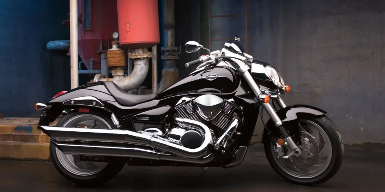 Czarny Suzuki Boulevard 1800 lśni w blasku przemysłowego otoczenia. Potężny silnik i chromowane detale przyciągają wzrok.