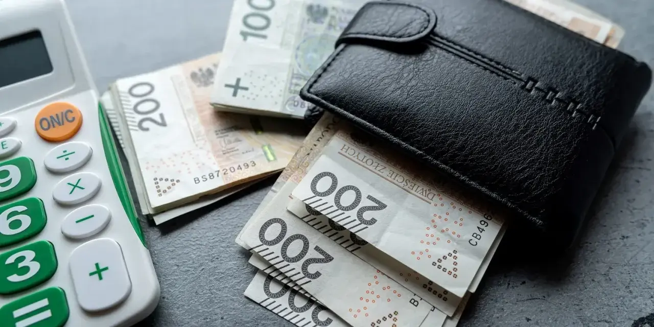 Portfel z polskimi banknotami i kalkulatorem. Nowa praca to szansa na lepsze zarobki.