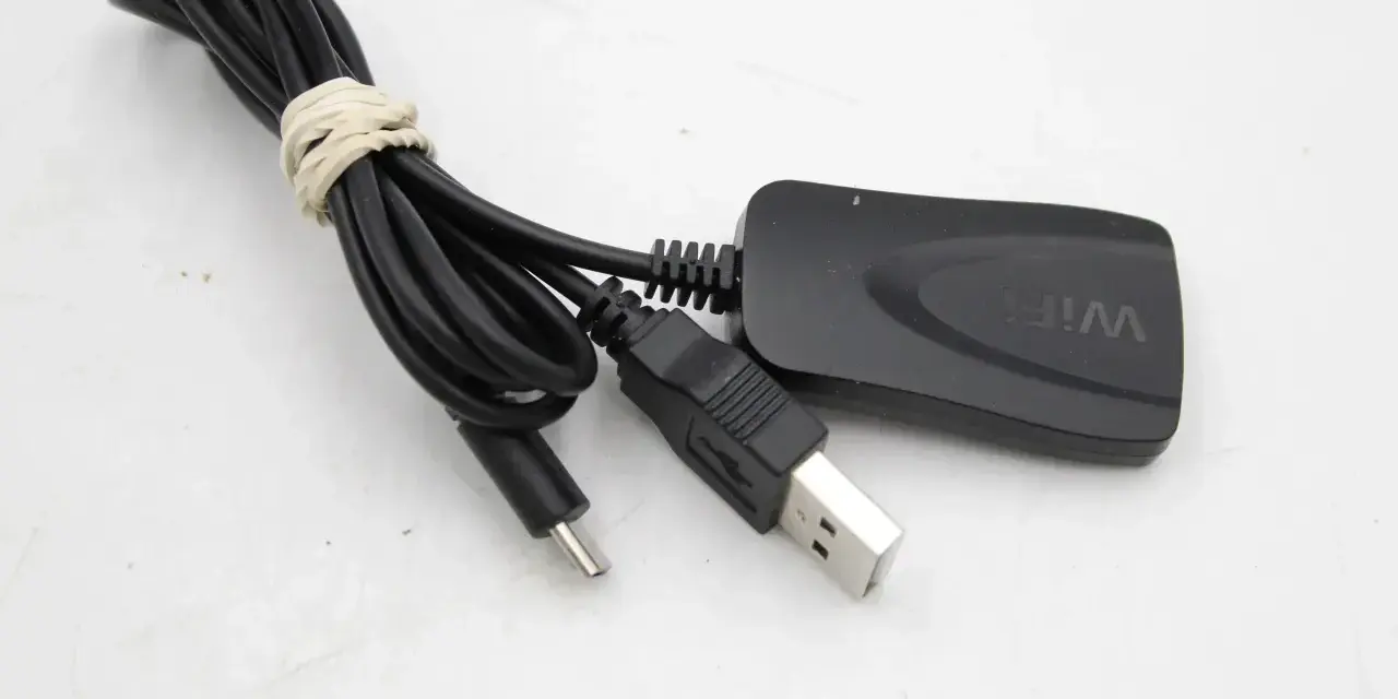 Czarny adapter Wi-Fi z kablem USB i złączem micro USB. Idealny, by dowiedzieć się, jak zrobić smart TV z tradycyjnego telewizora.