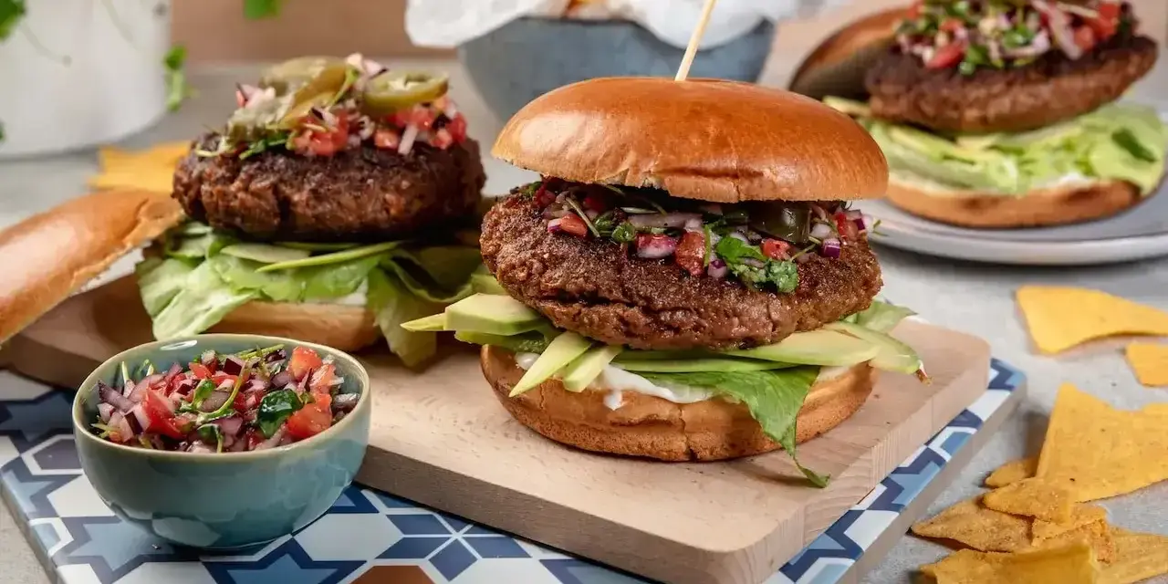 Dwa soczyste burgery z awokado i salsą. Idealna sałata do burgera to ta chrupiąca, zielona, która dodaje świeżości.