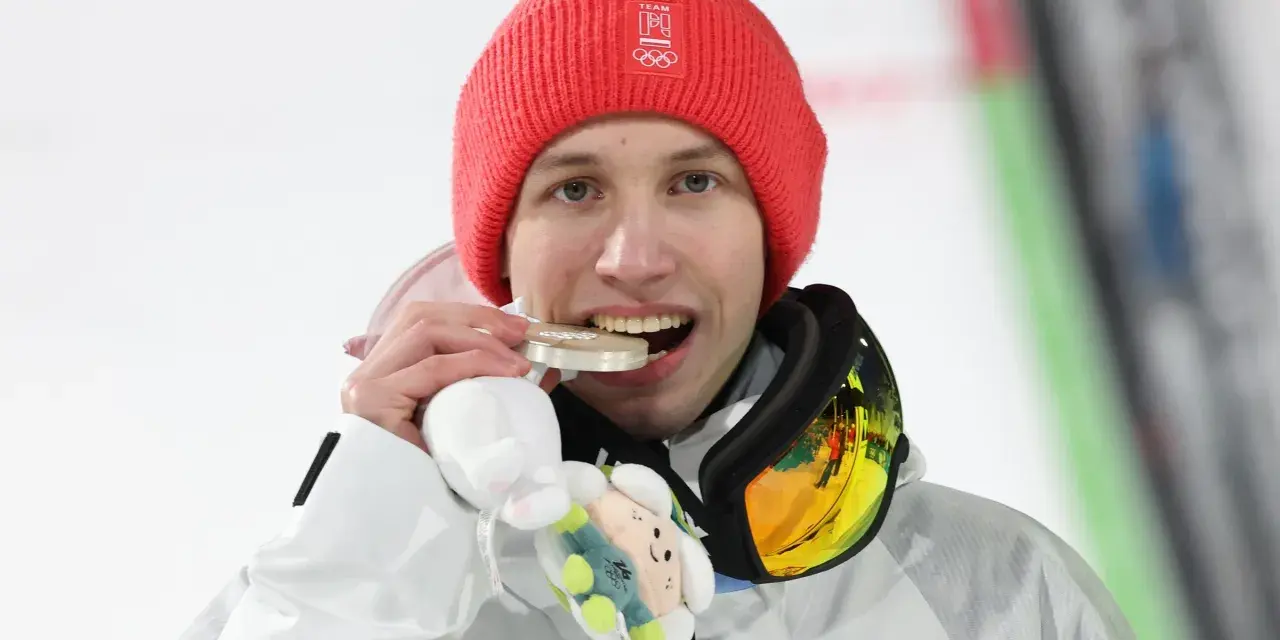 Kacper Tomasiak z medalem, który z dumą pokazują jego rodzice.
