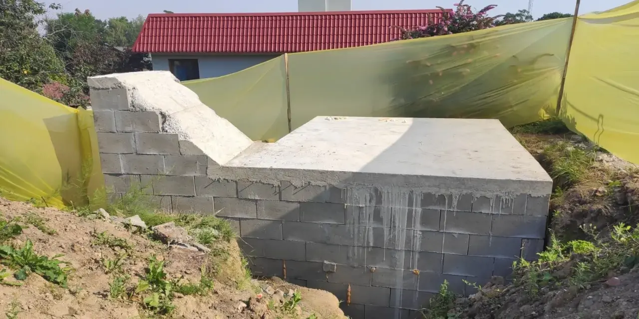 Budowa ziemianki: betonowy fundament i ściany z bloczków, gotowe do dalszych prac.
