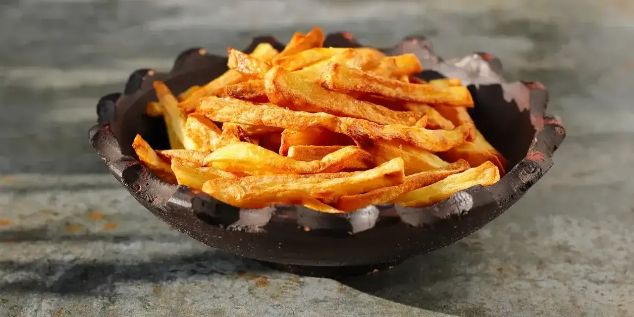 Złociste, chrupiące frytki z airfryer w misie. Idealna przekąska, która zachwyci każdego.