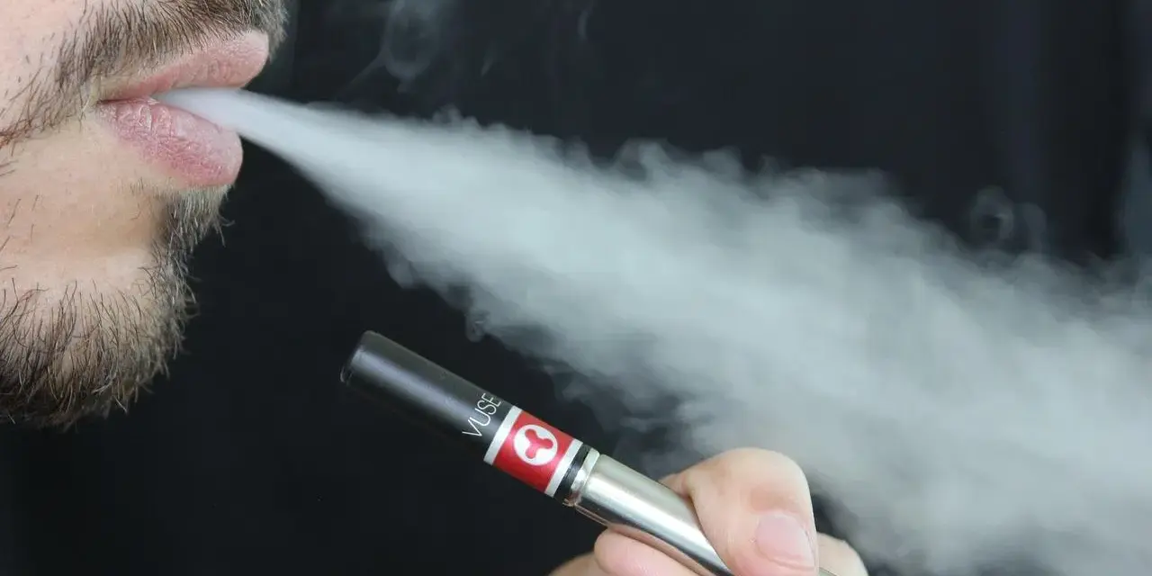 Hombre vapeando con un dispositivo Vuse, exhalando vapor. Una opción para quienes buscan vapers sin nicotina y cuidan su salud.