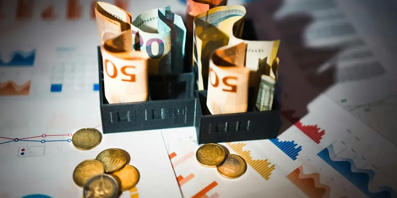 Billets d'euros enroulés dans des porte-billets, pièces et graphiques financiers. Illustration de la rémunération mandataire social.