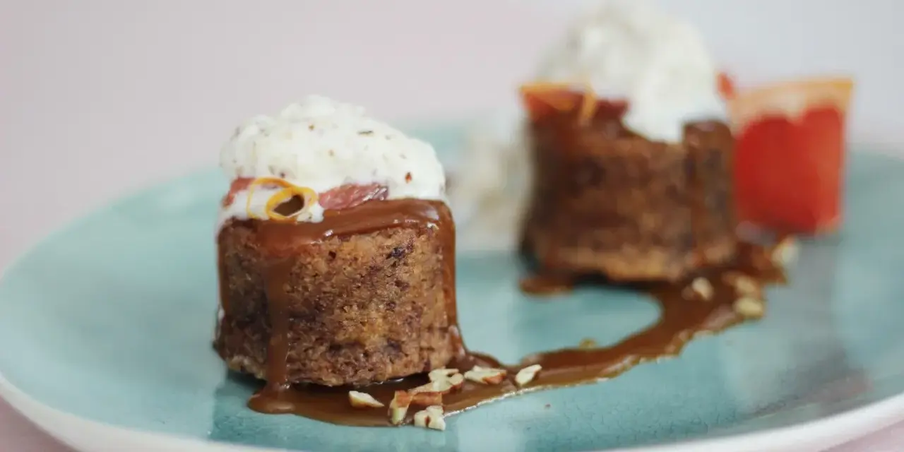 Zwei kleine Kuchen mit Karamellsauce, Nüssen und Sahne. Die süße Glucose-Verwendung macht sie unwiderstehlich.
