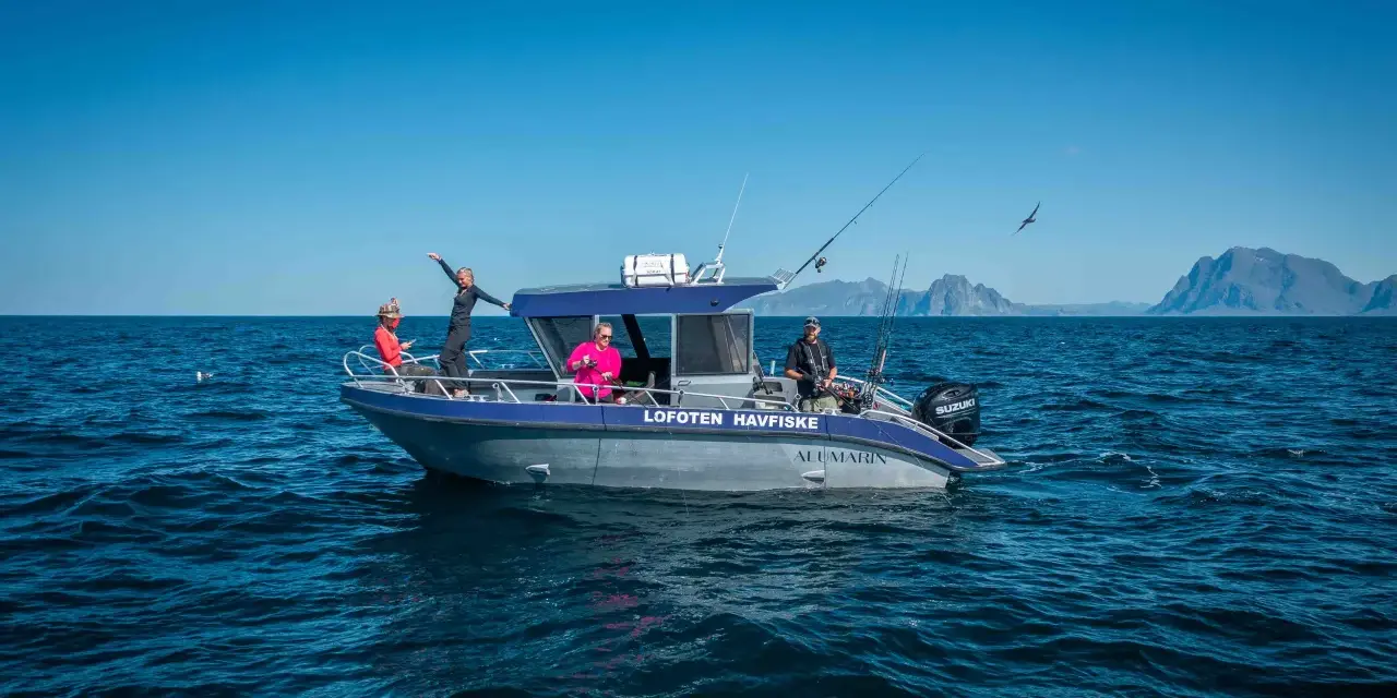 Fisketur i Nordnorge med båten "Lofoten Havfiske". Soligt och blåsigt, med berg i bakgrunden.