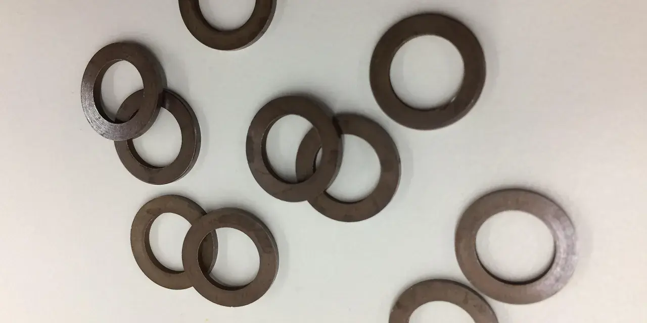 Un gruppo di rondelle alzaporta marroni, usate per regolare l'altezza delle porte.