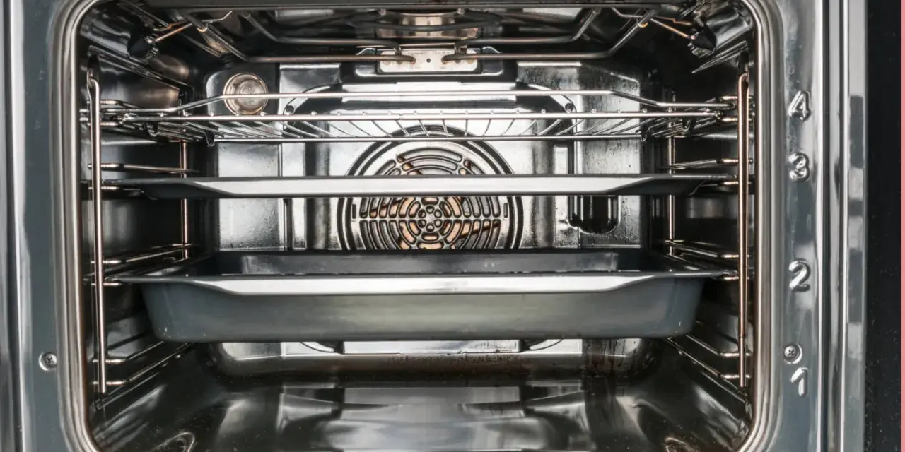 Interior de un horno con rejillas y bandejas, mostrando el ventilador.
