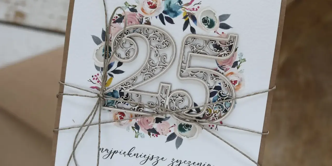 Elegancka kartka z napisem "25 lat małżeństwa jakie to gody", ozdobiona kwiatami i ażurową liczbą 25.