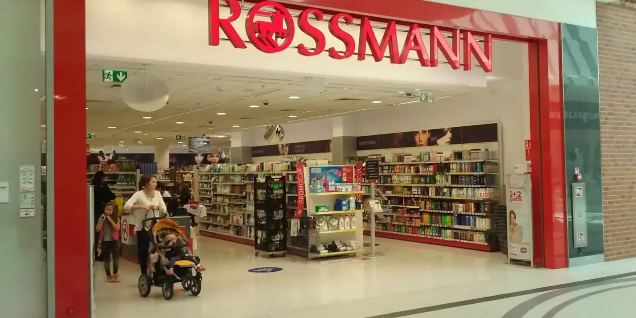 W Rossmannie, gdzie można zrobić wywołanie zdjęć z kliszy, matka z dziećmi robi zakupy.