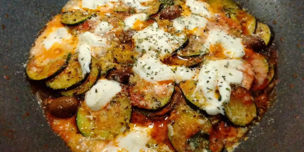 Zucchine alla pizzaiola in padella, con pomodoro, mozzarella filante e olive. Un piatto saporito e facile da preparare.