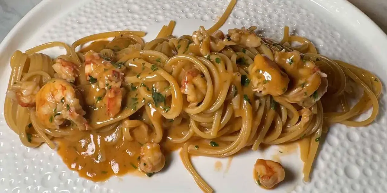 Spaghetti cremosi con mazzancolle e prezzemolo tritato, un piatto invitante e saporito.