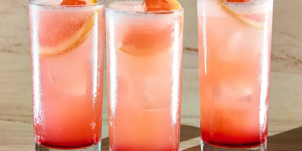 Trzy orzeźwiające drinki: Tequila Sunrise i Paloma, z plasterkami grejpfruta i lodem.