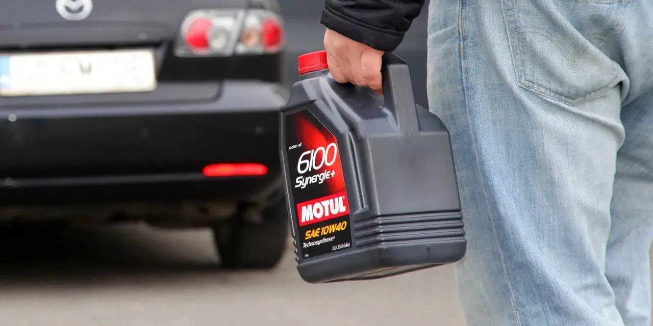 Mężczyzna niesie zużyty olej silnikowy Motul. Wiesz, gdzie oddać zużyty olej?