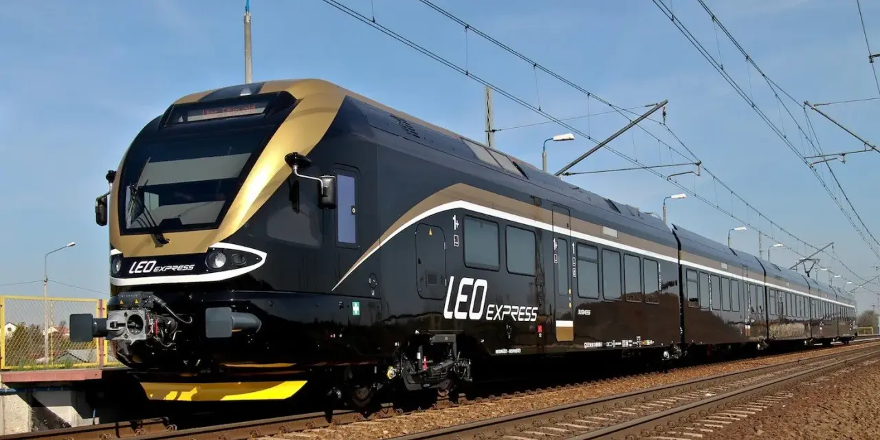 Nowoczesny, czarny pociąg LEO Express ze złotymi akcentami na torach.