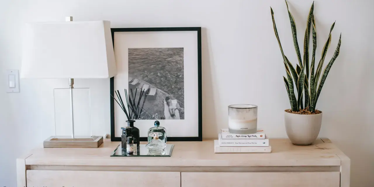 Stilvolle Kommode dekorieren: Lampe, Bild, Duftstäbchen, Kerze und Pflanze schaffen eine harmonische Atmosphäre.