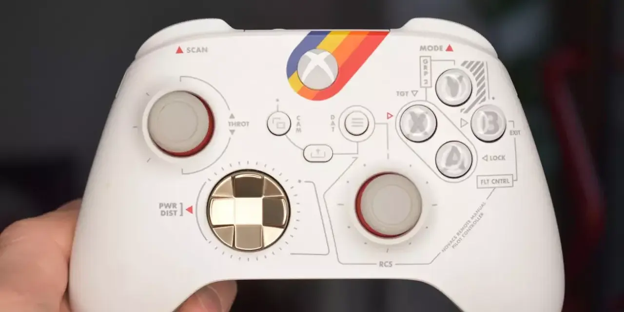 Biały kontroler Xbox z tęczowym paskiem i oznaczeniami przypominającymi kokpit. Idealny do testów xbox pad.