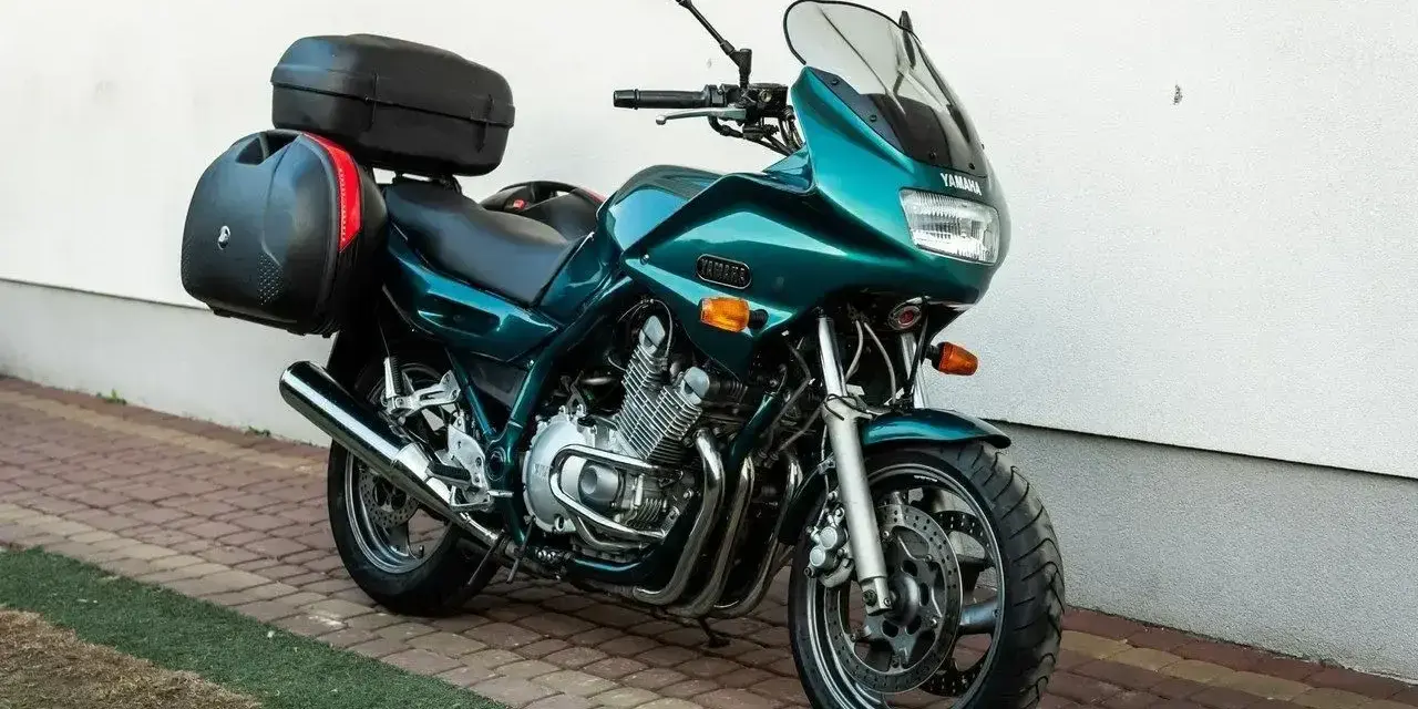 Zielony motocykl Yamaha XJ 900 z kuframi, gotowy na dalekie podróże.