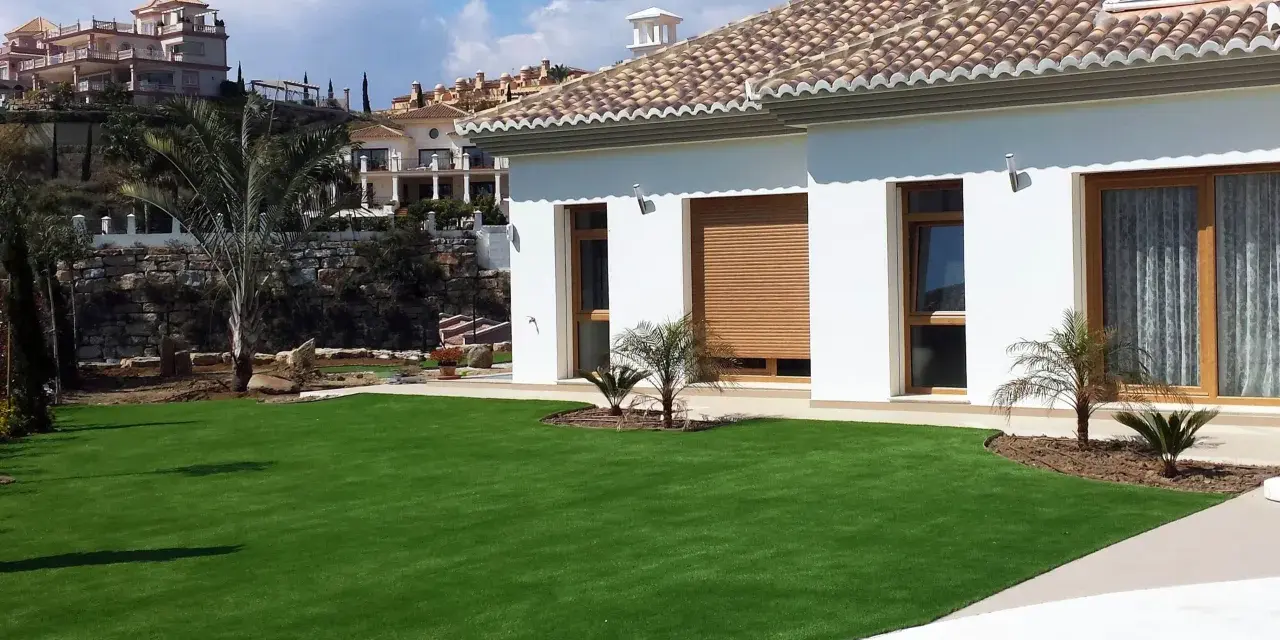 Modern villa con césped artificial en terrazas. Ideas para jardines de bajo mantenimiento y aspecto impecable.