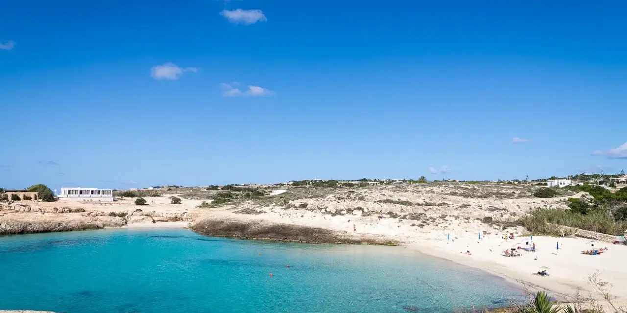 La **Cala Croce a Lampedusa** offre acque cristalline e una spiaggia dorata, ideale per rilassarsi sotto il sole.
