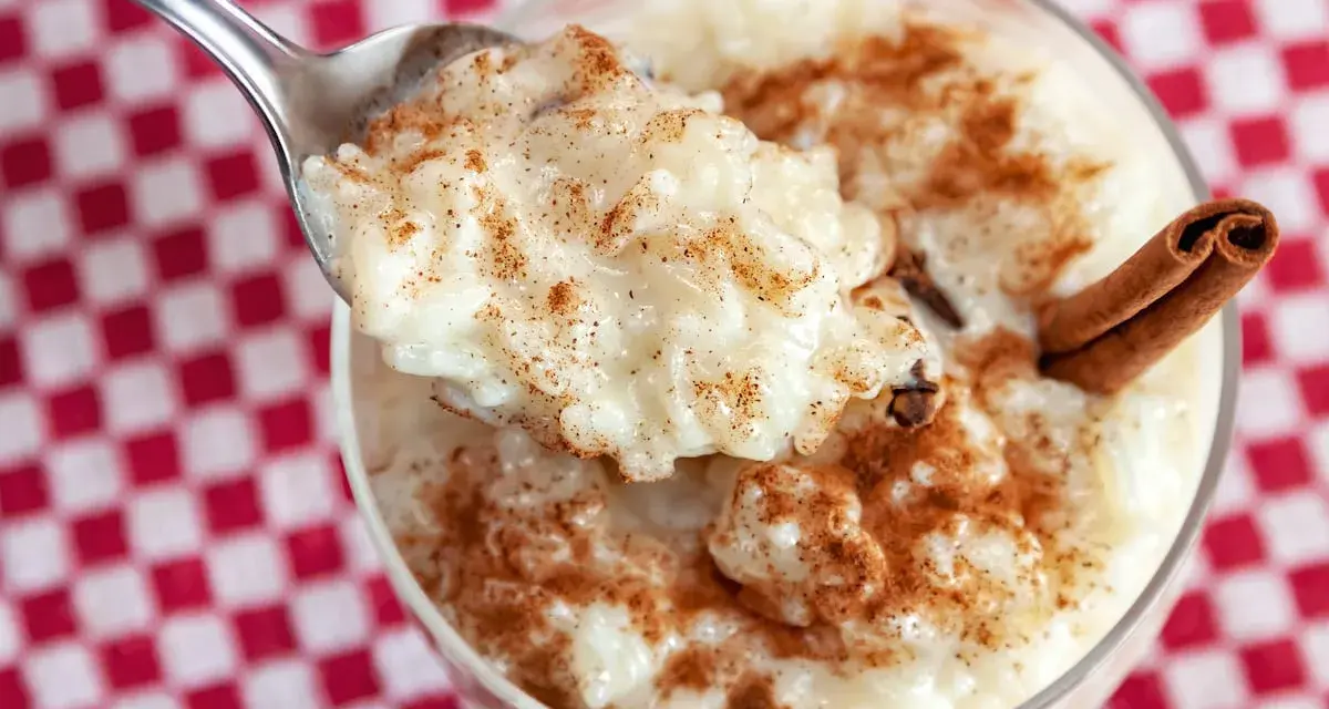 Cuchara con cremoso arroz con leche, espolvoreado con canela. ¿Quién inventó el arroz con leche? ¡Este postre es un clásico!