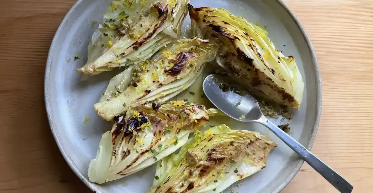 Ugnsbakad spetskål med citron och örter, serverad på en tallrik med en sked.