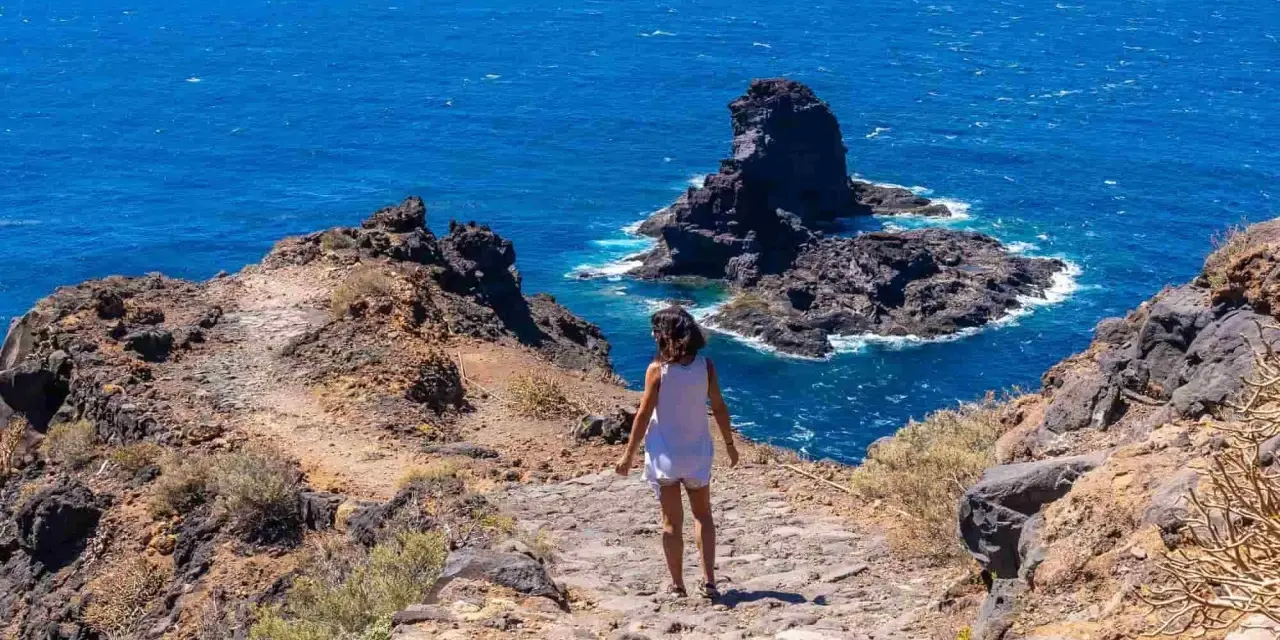 Sentiero roccioso verso il mare blu, un assaggio delle isole Canarie quali sono.