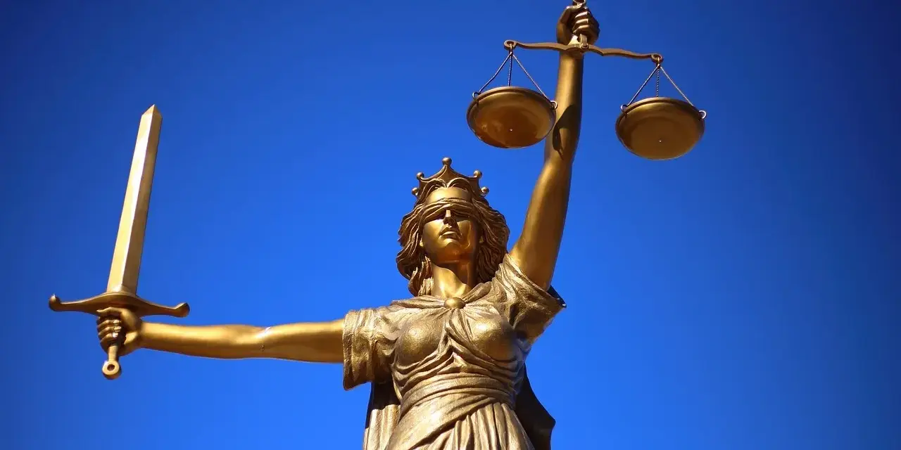 Złota Temida z mieczem i wagą, symbol sprawiedliwości, jak europejski tytuł egzekucyjny.