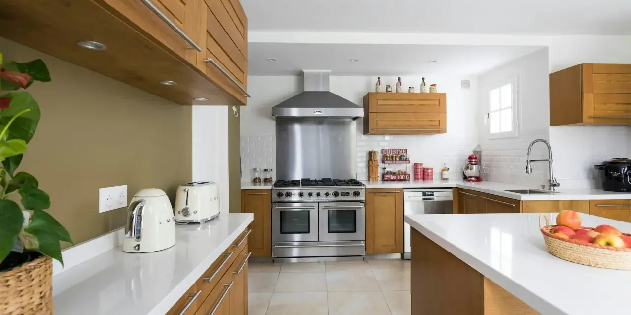 Cuisine moderne avec îlot central, électroménagers en inox et bois. Idéal pour estimer le prix rénovation maison m2.