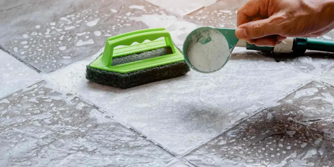 Nettoyer carrelage extérieur antidérapant avec une brosse et une poudre nettoyante.