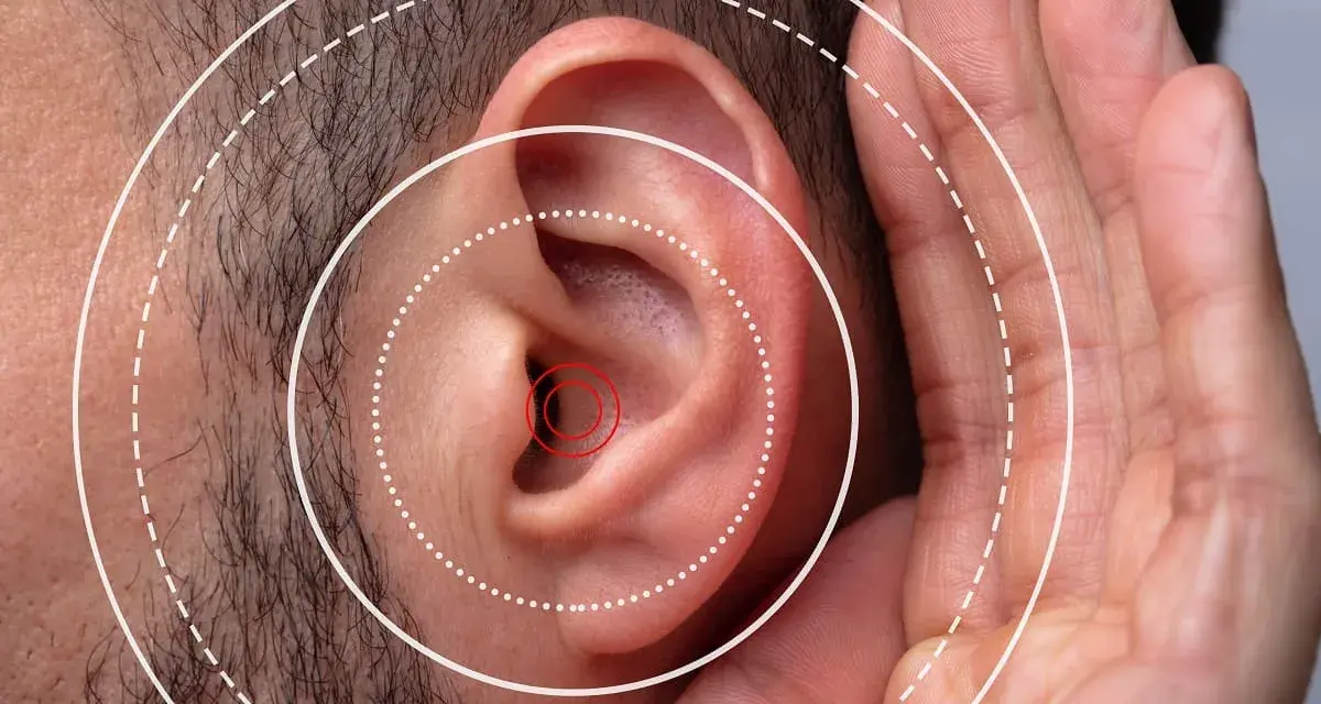 Gros plan sur une oreille humaine avec des cercles concentriques symbolisant le son. Une main est placée près de l'oreille, suggérant une gêne ou une irritation oreille boule quies.