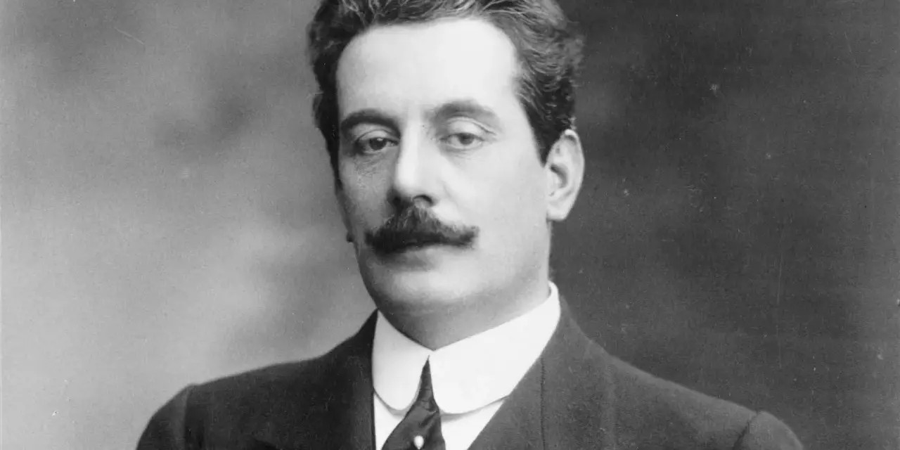 Giacomo Puccini, kompozytor słynnych **puccini opery**, w eleganckim garniturze i z charakterystycznymi wąsami.