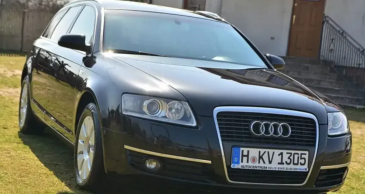 Czarny Audi A6 C6 3.0 TDI na trawie przed domem.