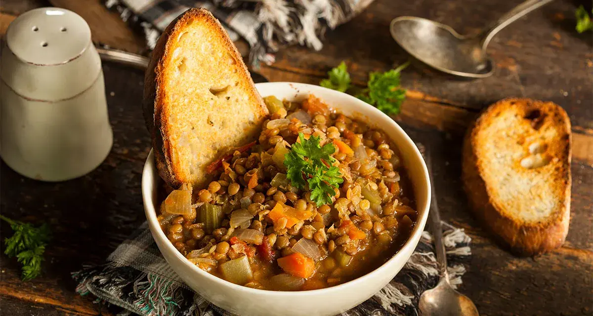 Zuppa di lenticchie ricca e saporita, servita con pane tostato e prezzemolo fresco. Un classico tra le ricette con lenticchie.