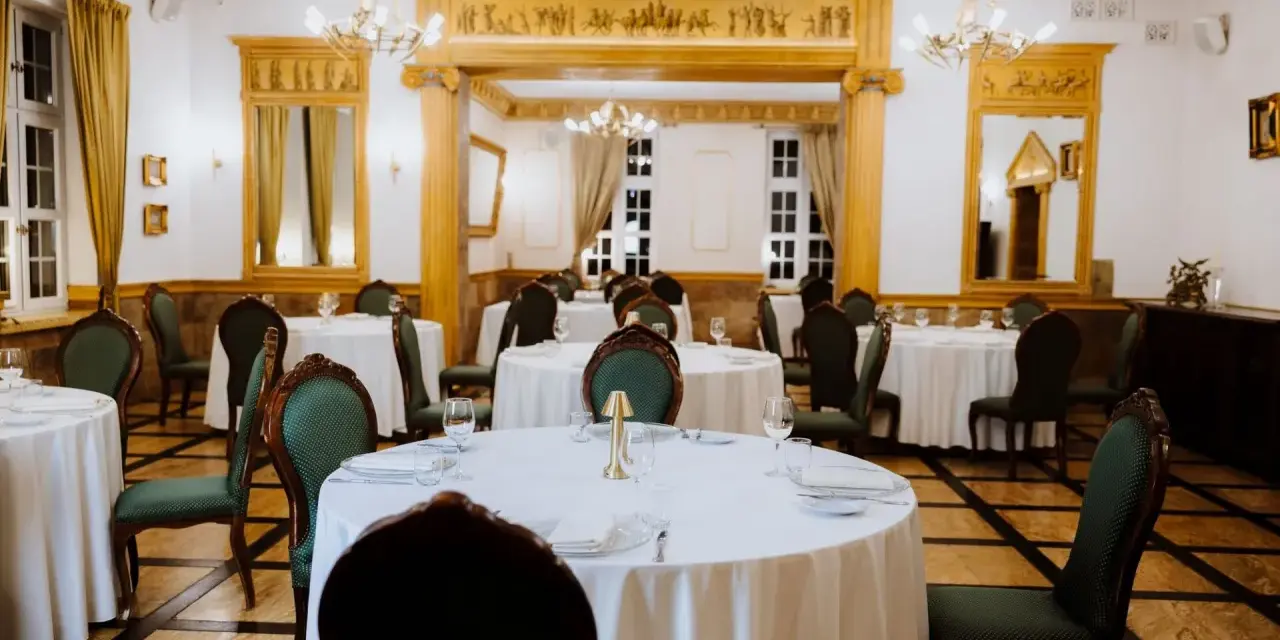 Elegancka sala bankietowa w lisewskim dworze, nakryte stoły czekają na gości.