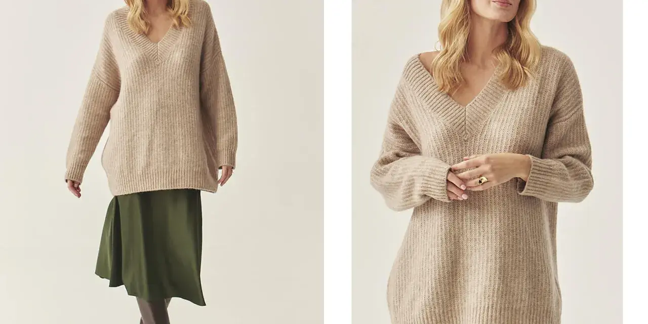 Modelka w beżowym swetrze w stylu oversize i zielonej spódnicy.